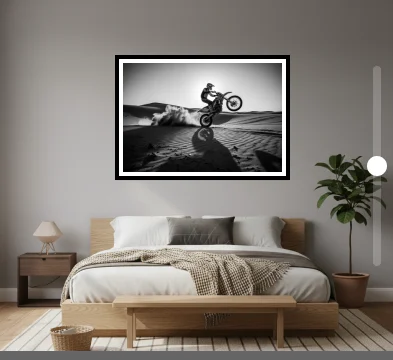 A framed black and white print previewed above a bed
